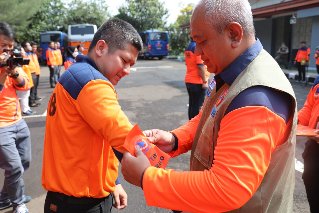 Deputi Bidang Logistik dan Peralatan Lilik Kurniawan menyematkan ban lengan kepada koordinator TRC Bravo saat Apel Kesiapsiagaan TRC Logpal di Gudang Logistik BNPB, Bogor, Jawa Barat, Rabu (3/5).